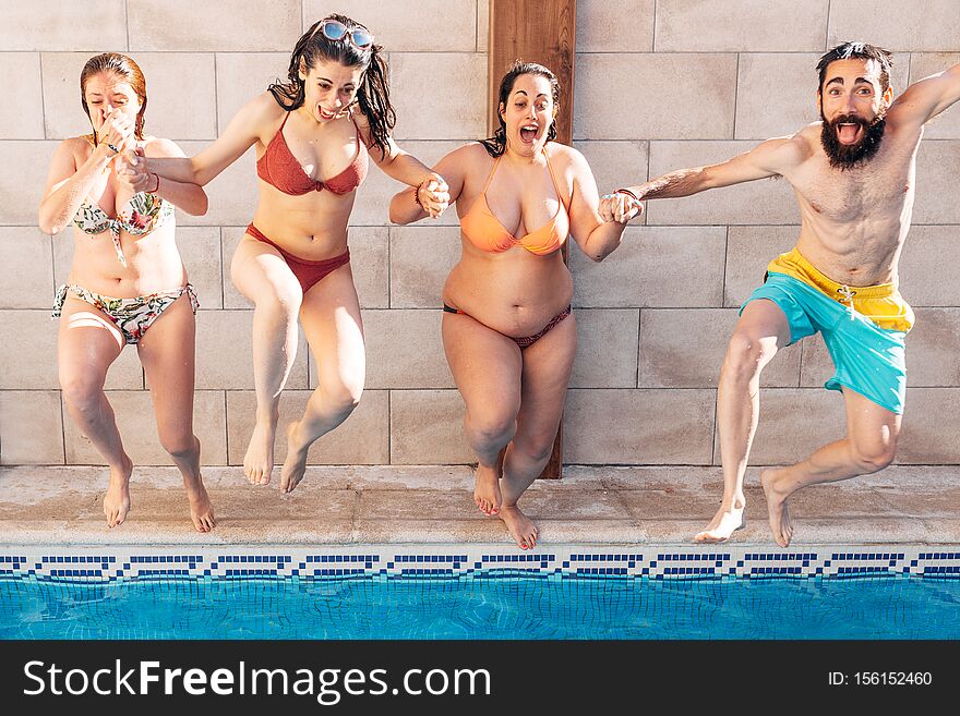 Group Of Happy Friends Holding Hands And Jumping In Pool. Young Diverse Culture People Having Fun In Vacation. Holiday And