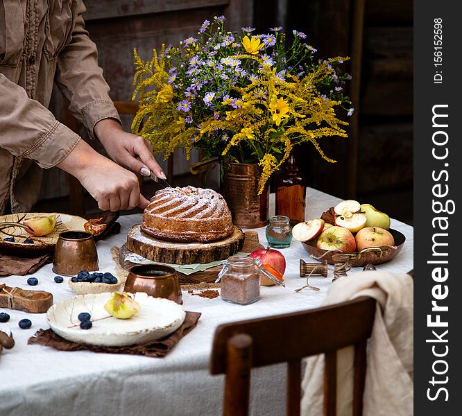 Beautiful outdoor still life in country garden with bundt cake on wooden stand on rustic table