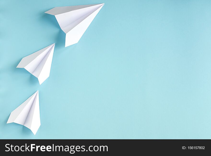 White paper planes on blue background composition