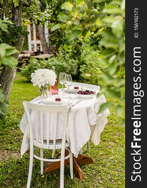 Outside table set with flowers and two serving plates with sweet cherry