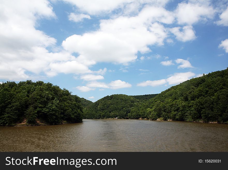 Beautiful blue cloudy sky and river with forest on the sides. Beautiful blue cloudy sky and river with forest on the sides