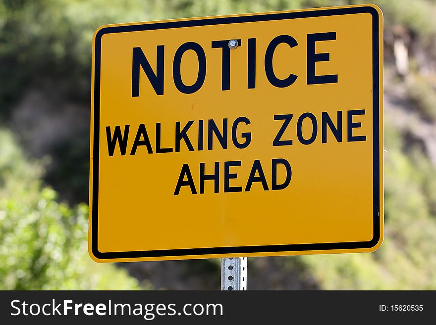 A sign letting people know it is a walking zone. A sign letting people know it is a walking zone