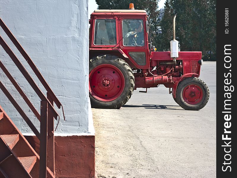 Red Tractor Resting In A White Wall