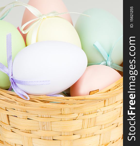 Close up of basket filled with pastel colored eggs. Close up of basket filled with pastel colored eggs