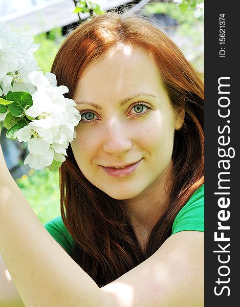 Young  woman standing at apple tree in white blossom. Young  woman standing at apple tree in white blossom