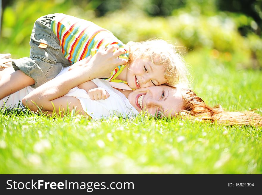 Beautiful young mother with her  daughter playing on grass . summer. Beautiful young mother with her  daughter playing on grass . summer.