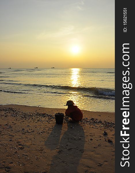 Sunrise and old woman at Cha-am Beach ,Thailand