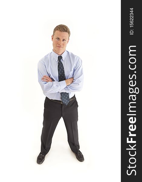 Full length portrait of smiling young businessman standing with arms crossed across chest. Full length portrait of smiling young businessman standing with arms crossed across chest