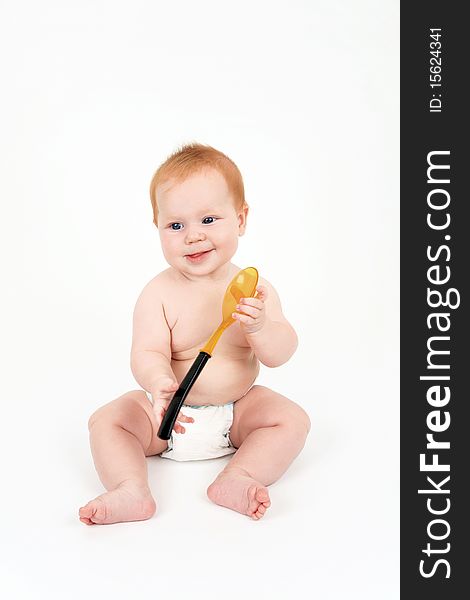 The child with a spoon in hands on a white background
