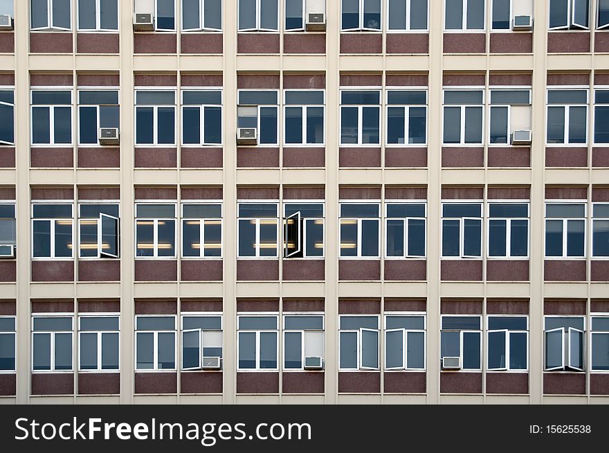 A straight flat view of an office building with windows.