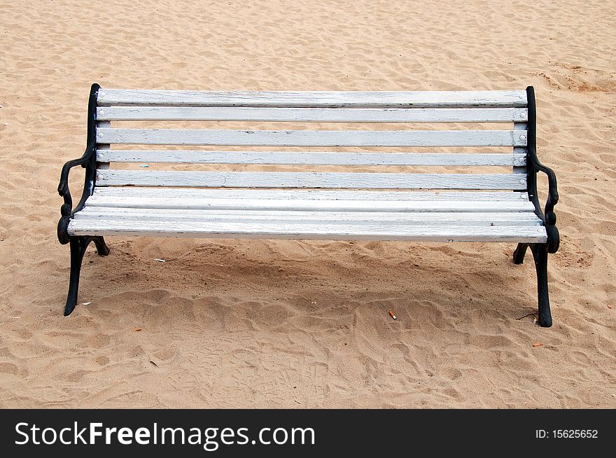 Wooden bench and butts over the sand