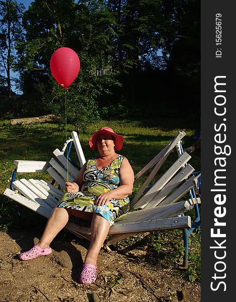 The woman with a balloon, sitting on a bench. The woman with a balloon, sitting on a bench