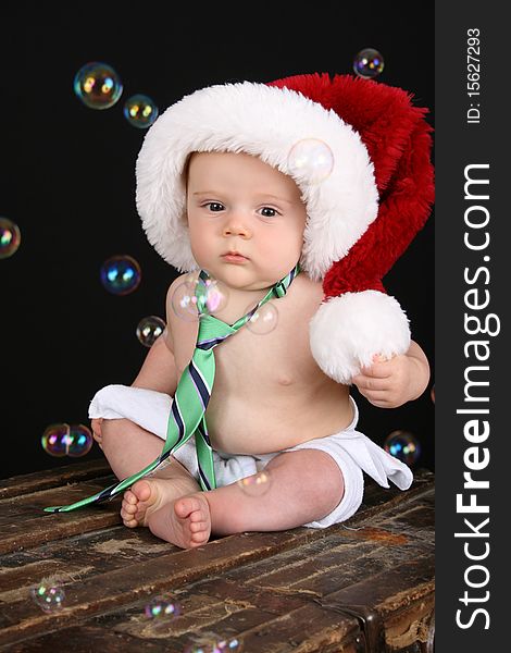 Cute christmas baby boy sitting on an antique trunk