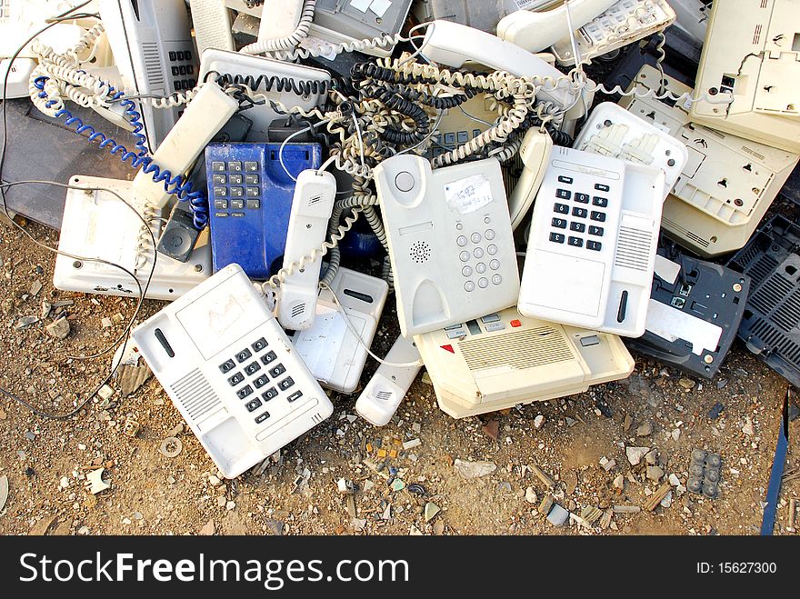 Stack of old broken telephones on the ground. Stack of old broken telephones on the ground