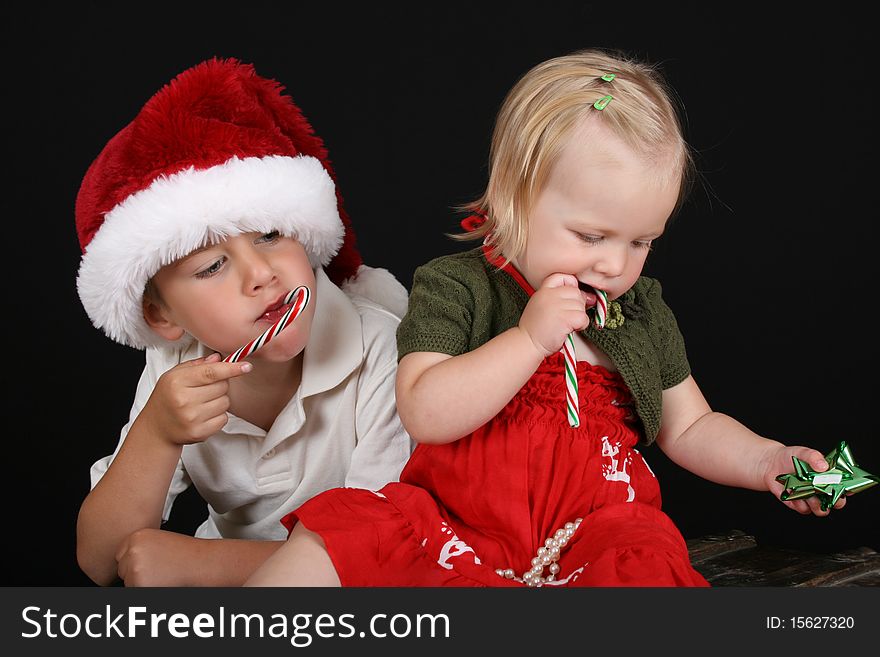 Christmas brother and sister eating Candy Canes. Christmas brother and sister eating Candy Canes