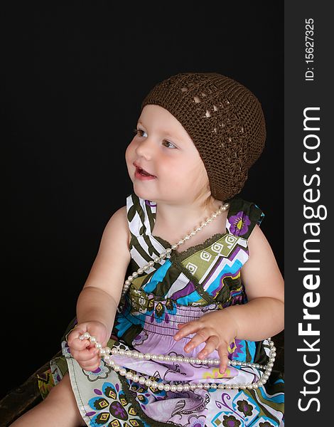 Beautiful toddler playing with a string of pearls