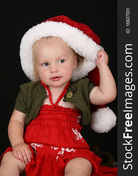 Cute blond girl wearing a red dress and christmas hat. Cute blond girl wearing a red dress and christmas hat