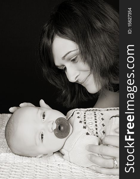 Beautiful mother and son against a black background