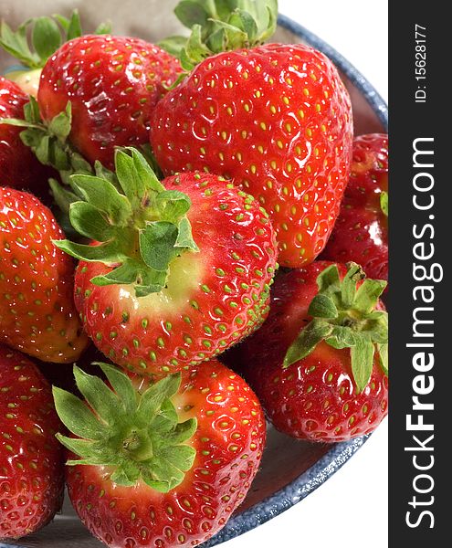 An overhead shot of ripe red strawberries in a bowl. An overhead shot of ripe red strawberries in a bowl.