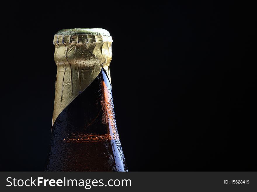 Closeup shot of beer bottle crown with black background.