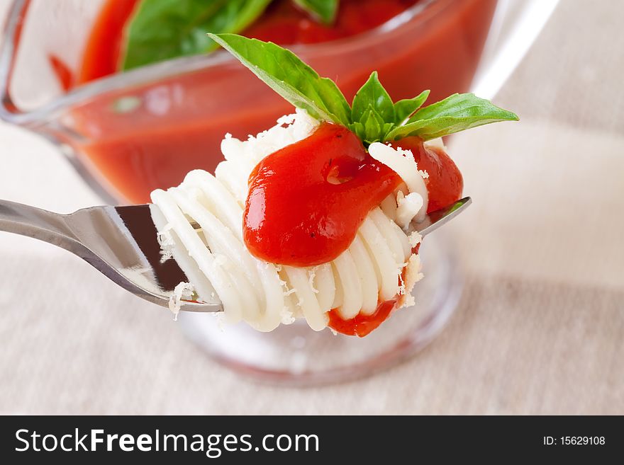 Spaghetti with sauce and parmesan cheese on a fork.