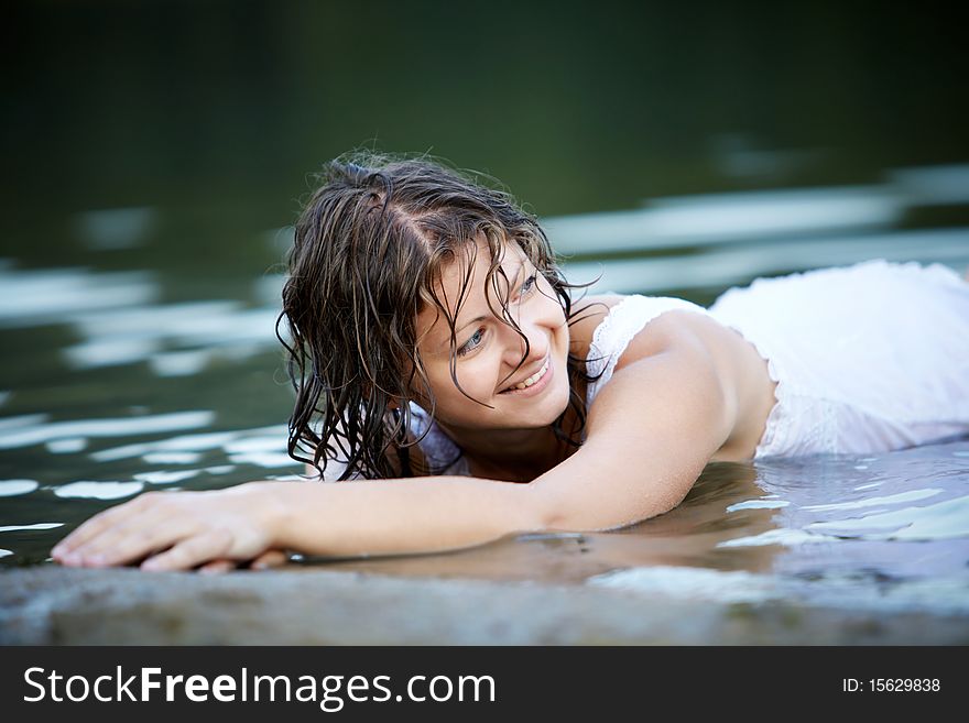 Portrait of beautiful girl in wet white dress outdoors on a beach. Portrait of beautiful girl in wet white dress outdoors on a beach