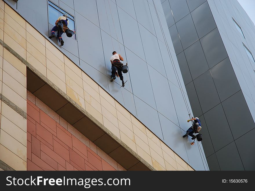 Image of people climbing up the wall of building. Image of people climbing up the wall of building