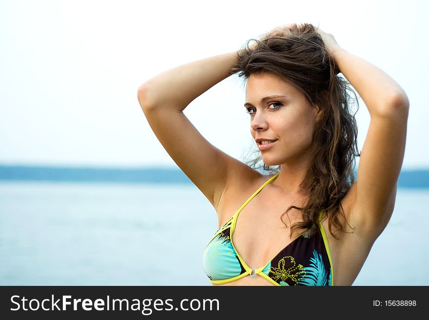 Beautiful woman in bikini relaxing on the river shore