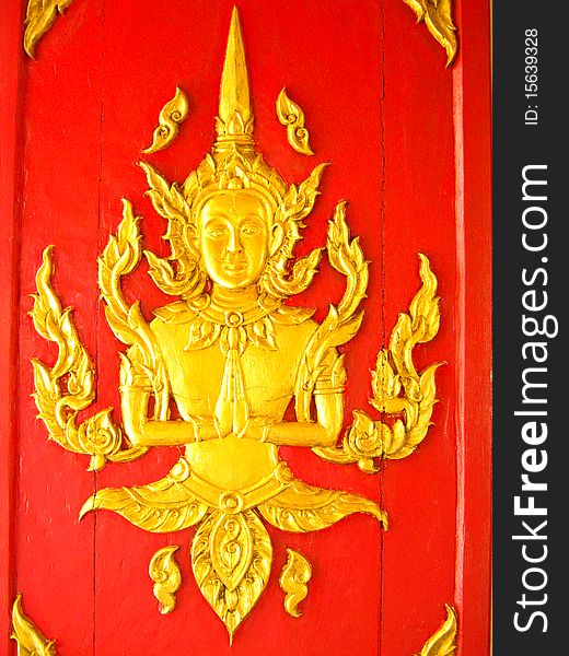Gold buddha statue on a red wall