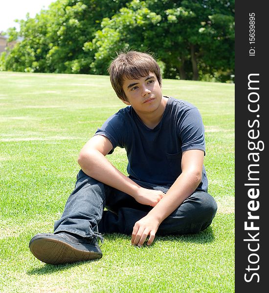 Portrait of a Young Boy Sitting on Grass