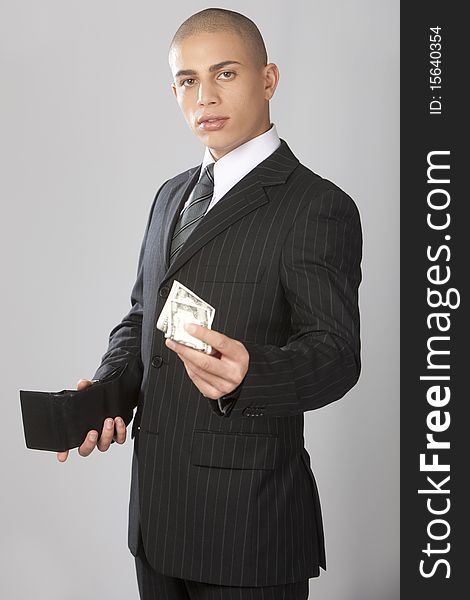 A young good looking businessman on a gray background. A young good looking businessman on a gray background.