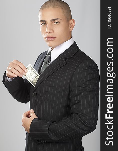 A young good looking businessman on a gray background. A young good looking businessman on a gray background.