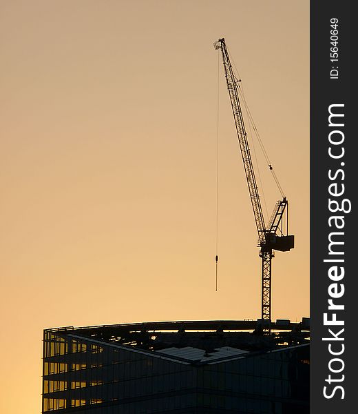 Under construction building against the coming sun. A city. Under construction building against the coming sun. A city.