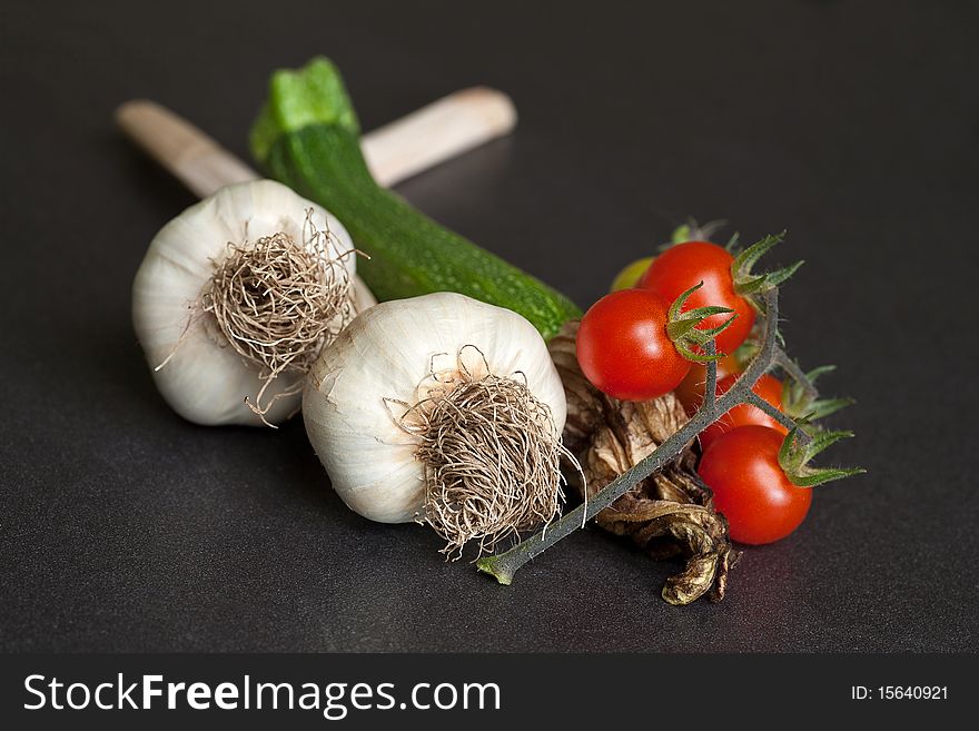 A selection of freshly-picked organic garden produce including garlic, tomatoes and courgette