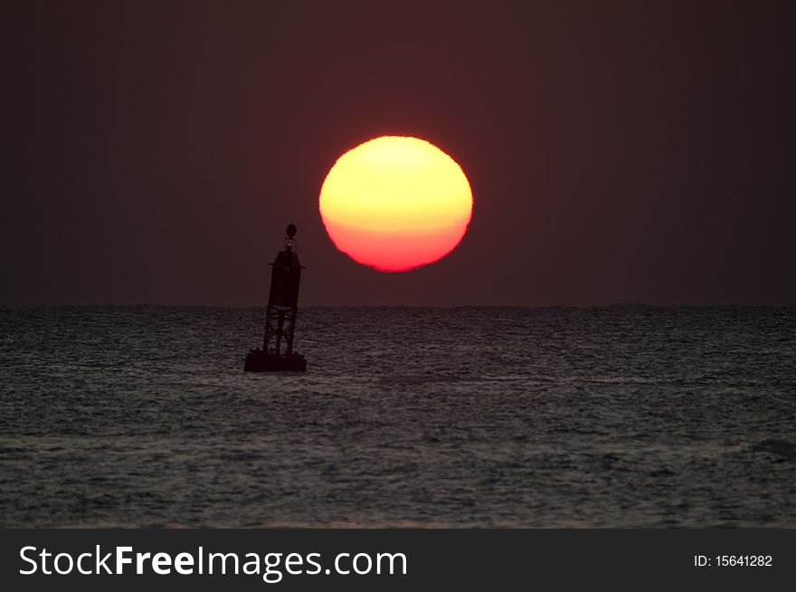 Sunrise over ocean and buoy