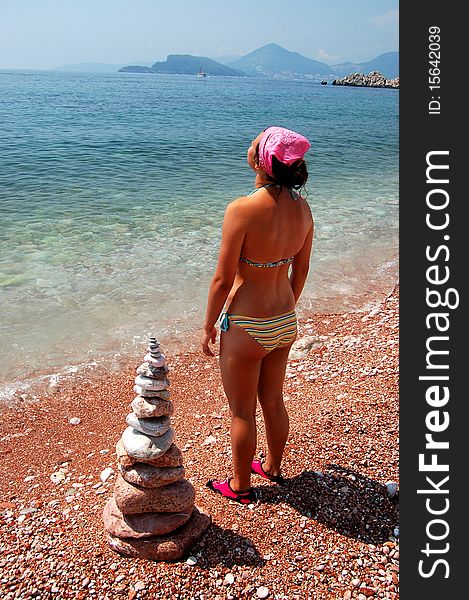 A girl is meditating on a beach in Montenegro. A girl is meditating on a beach in Montenegro