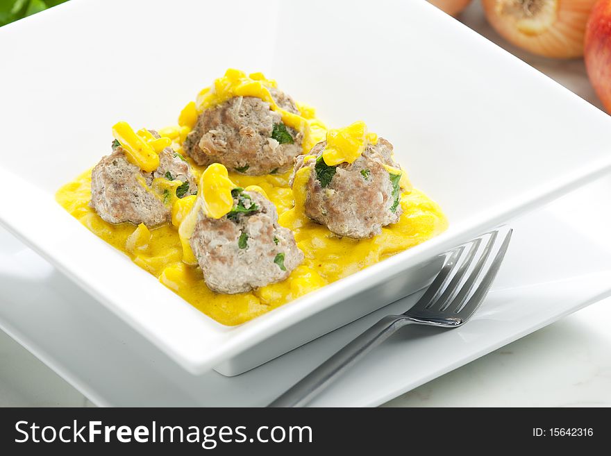 Minced meat and herbs balls in apple and curry sauce. Minced meat and herbs balls in apple and curry sauce