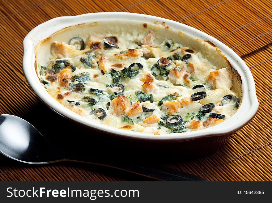 Baked gnocchi with salmon, spinach and black olivves