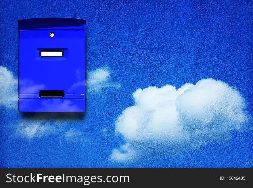 Photo of sky blue mail box on blue wall with clouds. Photo of sky blue mail box on blue wall with clouds