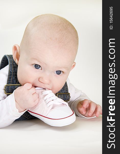 Portrait of lying down baby girl holding a shoe