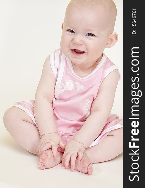 Sitting baby girl wearing pink dress