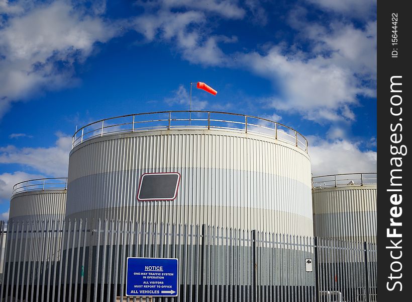 Fuel tanks in industrial area and blue sky with clouds