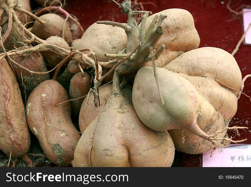 A big pile of sweet potatoes at the farmers market。