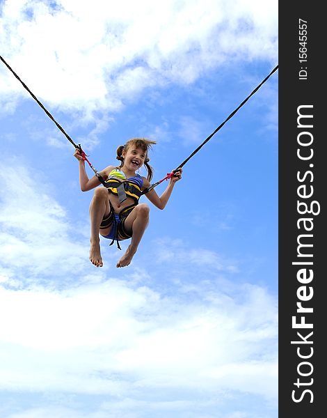 Girl jumping on ropes relating to the blue sky. Girl jumping on ropes relating to the blue sky