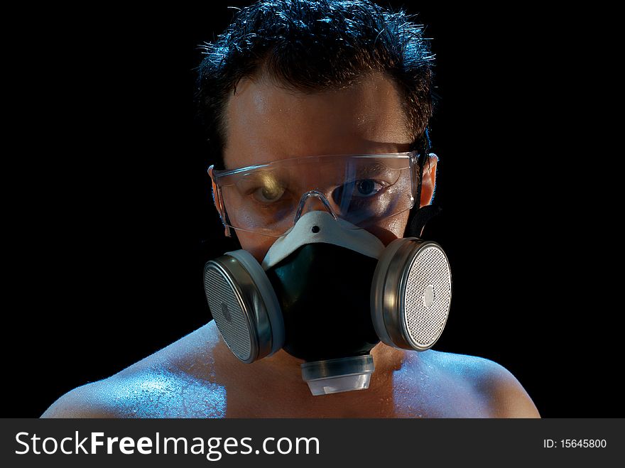 A man in a respirator and glasses suffering from smoke and heat in Moscow. Isolated on black. A man in a respirator and glasses suffering from smoke and heat in Moscow. Isolated on black.