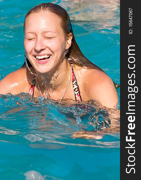 Blond girl swimming in the swimming pool closeup