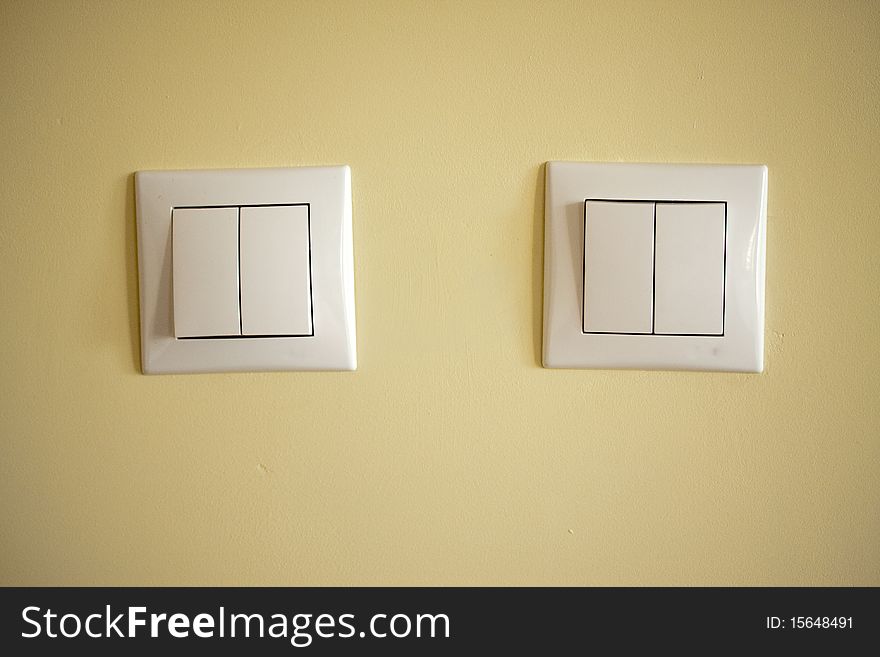 Two light switches on a creme background