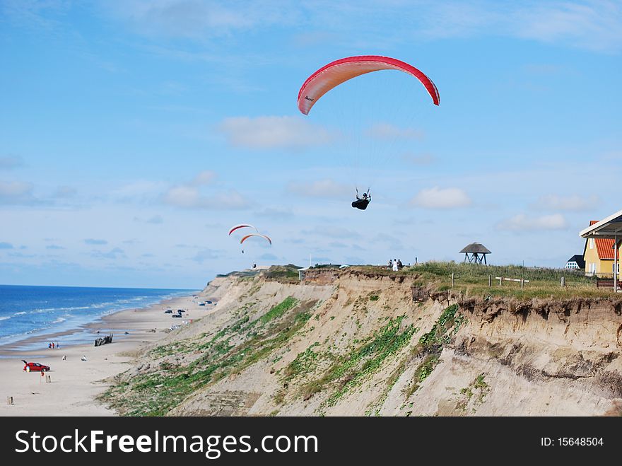 Paragliders flying over the beach on a sunny day