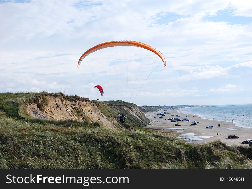 Paragliders flying over the beach on a sunny day