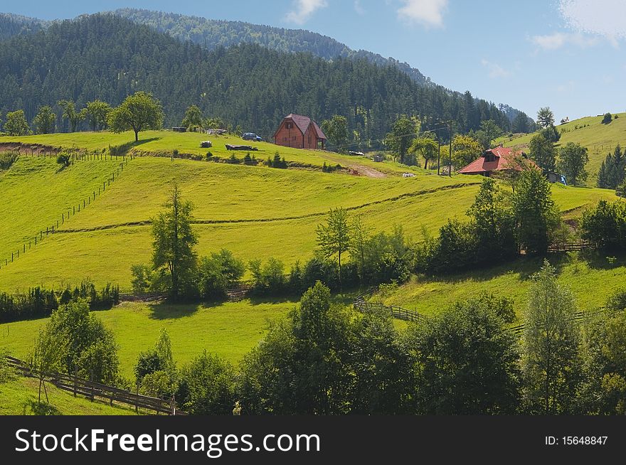 Beautiful country landscape showing mountains, forests, fields and meadows.